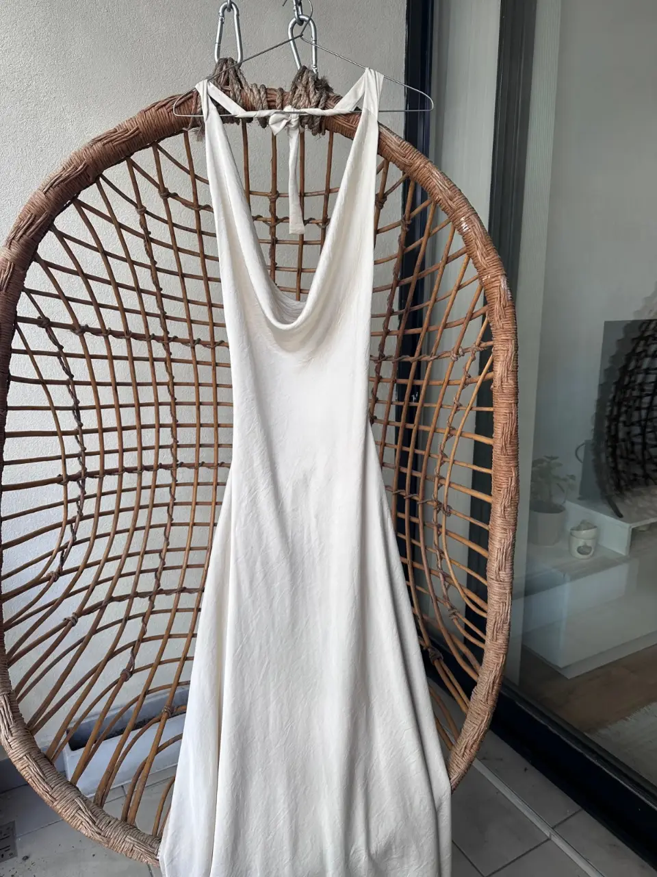 Vestido largo color marfil con cuello halter y espalda descubierta. Ideal para eventos especiales o salidas de verano. Diseño elegante y minimalista.