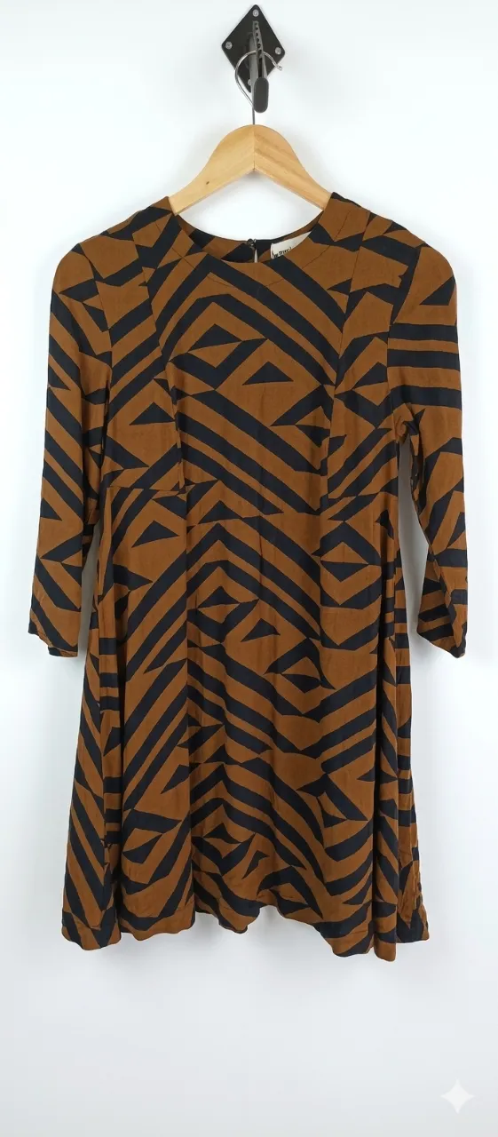Vestido marrón con estampado geométrico en negro. Posee mangas largas y cuello redondo.