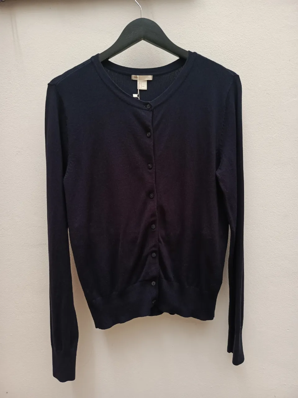 Cardigan azul marino con botones al frente y cuello redondo.