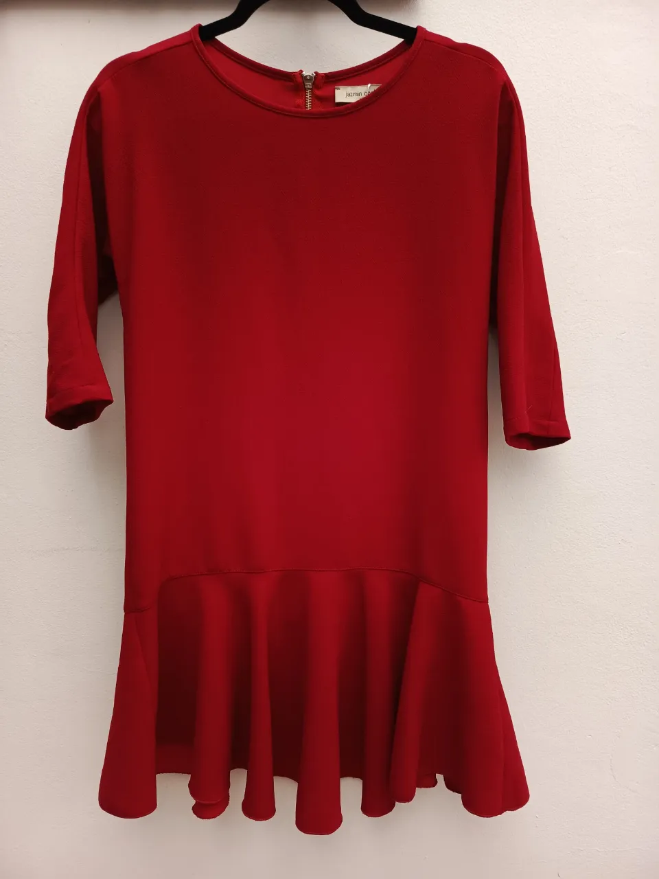 Vestido rojo de manga 3/4 con volado en la parte inferior. Cierre en la espalda.