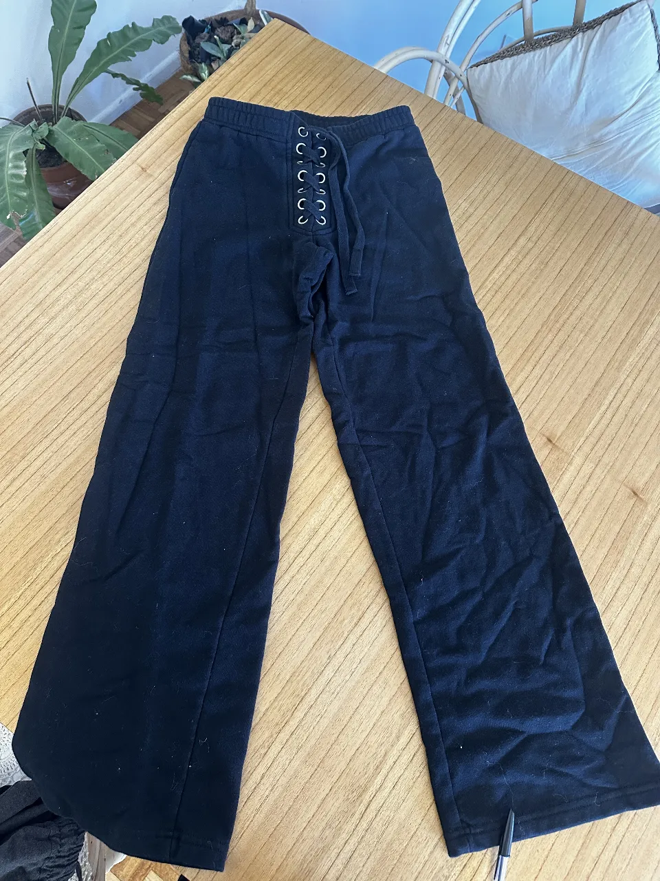 jogg Pantalón negro de mujer, con ajuste de cordones y detalle de ojalillos. Ideal para un look casual y cómodo. corte recto. calza espectacular. algodón y micro polar adentro