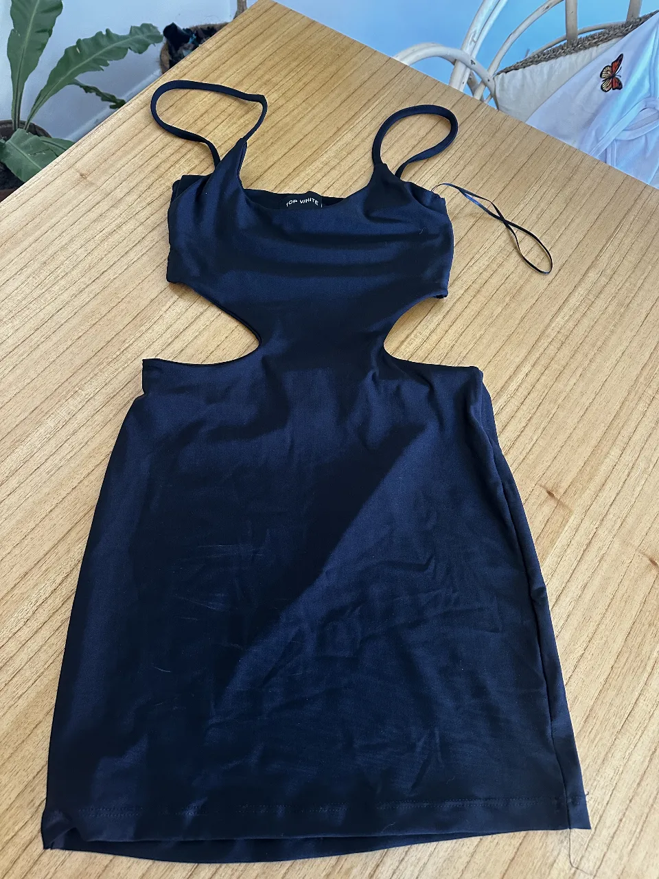 Vestido negro mini con aberturas laterales. Ideal para una salida nocturna o evento especial. Diseño moderno y sensual.