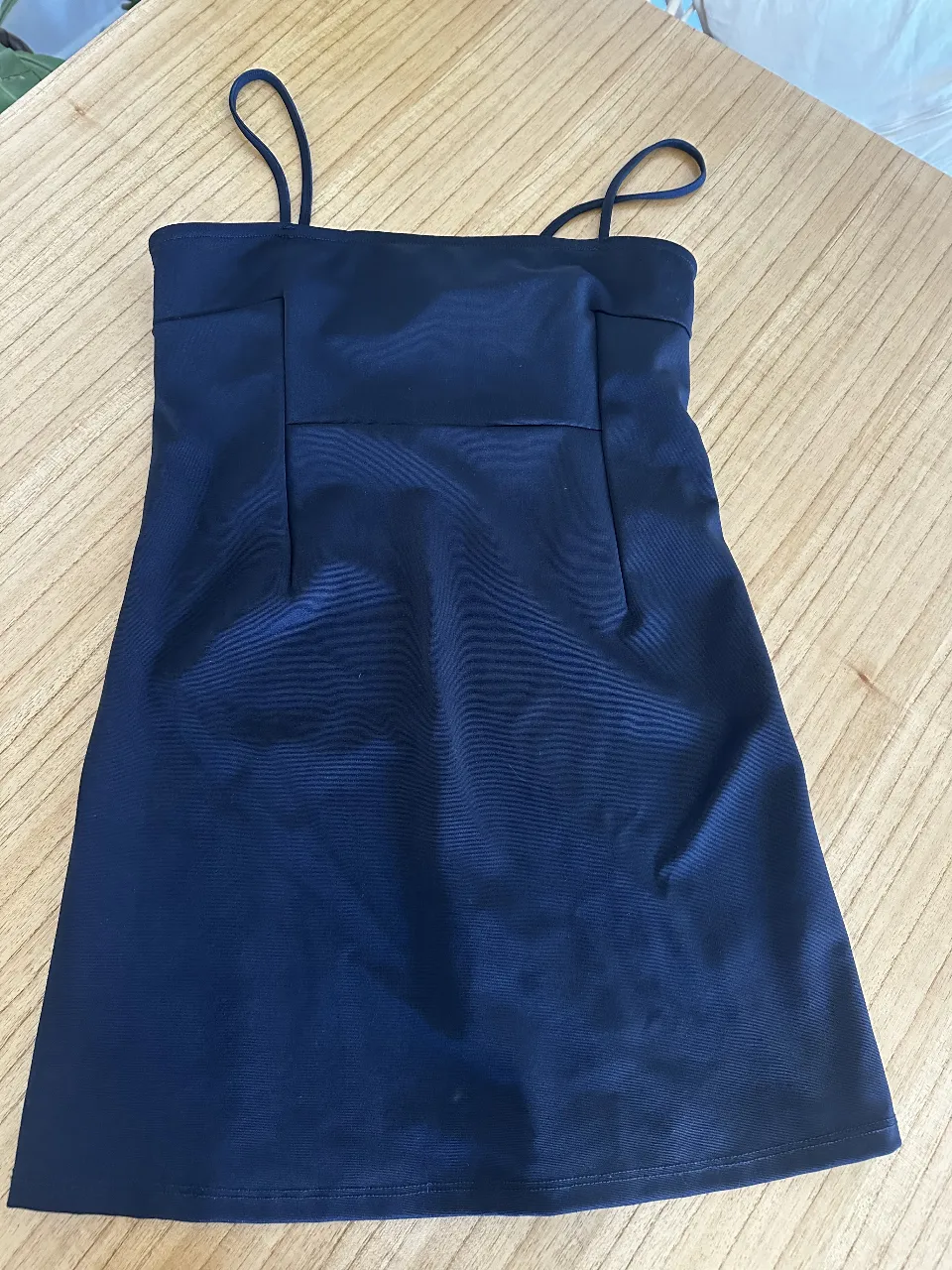 Mini vestido negro, con tirantes finos y un diseño elegante. Ideal para una salida nocturna o evento especial. Confeccionado con tela suave y adaptable. sacado de un vintage en Barcelona 