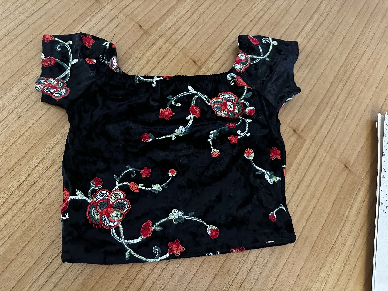 Top negro de terciopelo con bordados florales en rojo y blanco. Ideal para un look vintage y romántico. traído de un Vintage de España