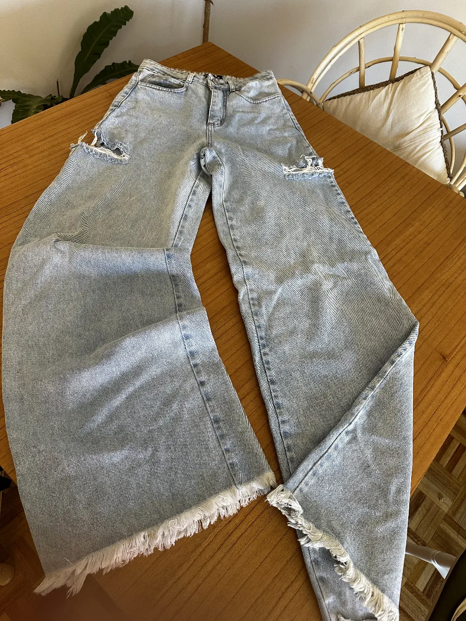 Jean 70s pata de elefanter, tiro alto, con roturas en las rodillas y corte ancho. Ideal para un look casual y moderno.
