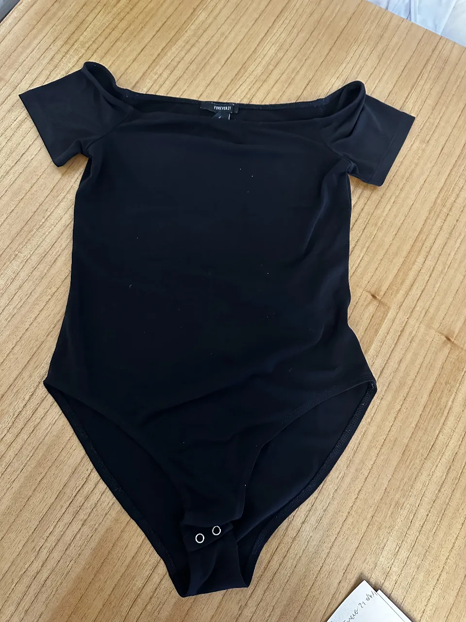 Body negro de Forever 21, con cuello bote y mangas cortas. Ideal para un look moderno y versátil.