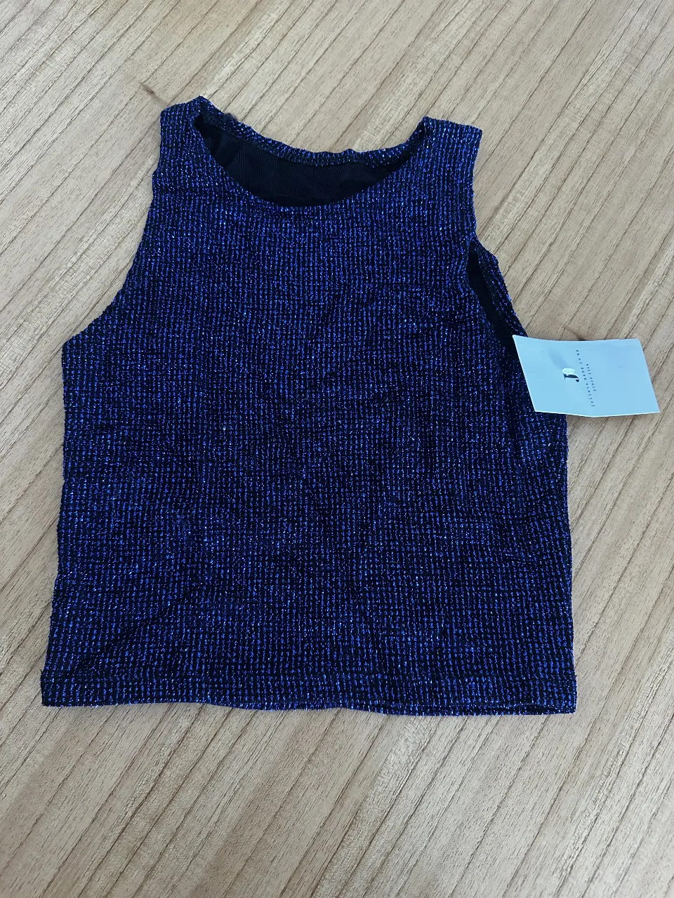 Top de mujer azul con brillo, ideal para fiesta o salida. Musculosa sin mangas, con cuello redondo y etiqueta.