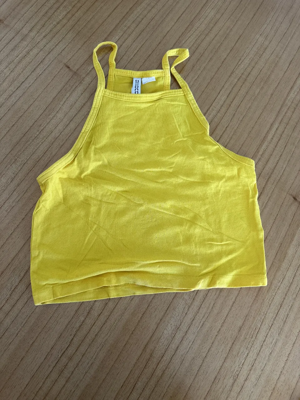 Top amarillo de mujer, con breteles finos y escote halter. Ideal para un look fresco y moderno.