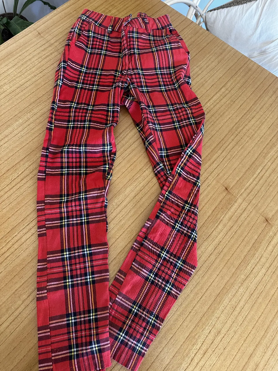 Pantalón de vestir para mujer, con estampado escocés en tonos rojos y negros. Corte cigarillo tiro alto con bolsillos y cierre, ideal para un look elegante y a la moda. elastizado