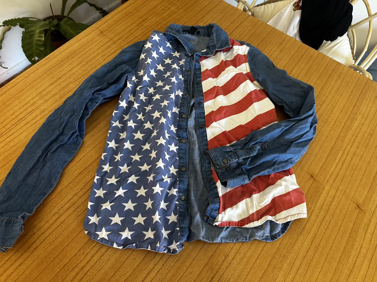 Camisa denim con estampado de la bandera de Estados Unidos. Diseño llamativo y patriótico, ideal para eventos informales o para expresar tu estilo único. Corte clásico y cómodo. 