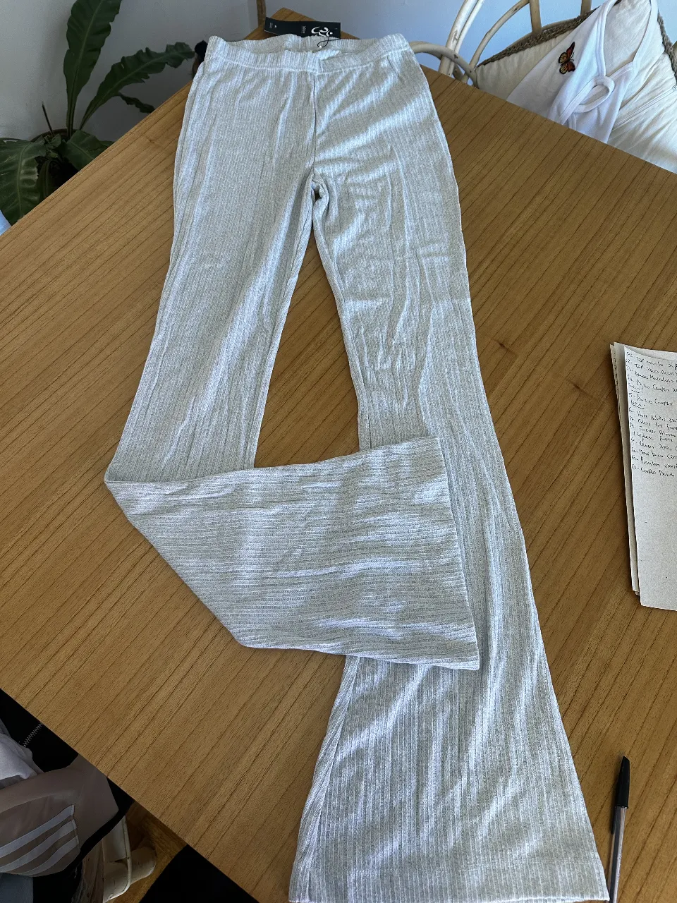 Pantalón de mujer estilo palazzo, de color gris claro. Confeccionado en tejido de punto acanalado, ideal para un look casual y cómodo. Perfecto para combinar con tops y zapatillas.