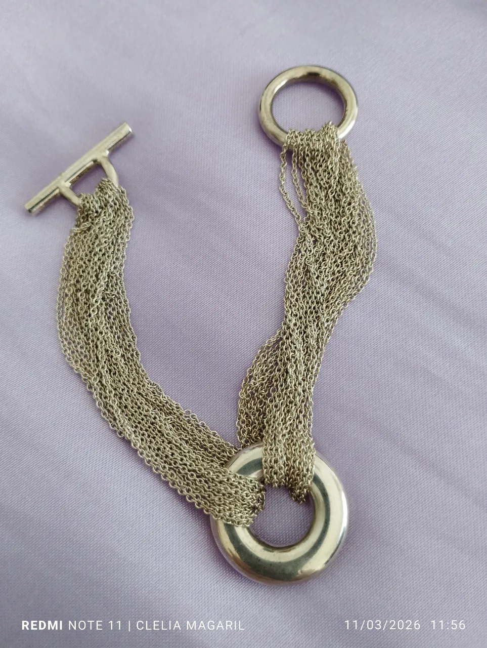 Pulsera de eslabones finos con dos aros metálicos y cierre tipo T.