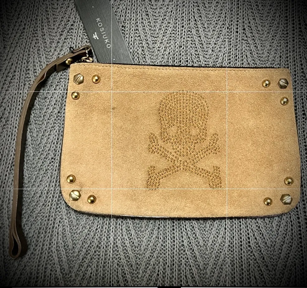 Sobre chico, de cuero y gamuza. Nuevo! 🌟 Tiene tachas y diseño de calavera. Cierre superior y correa de mano. Interior forrado, tiene bolsillo con cierre. La correa es color peltre. 