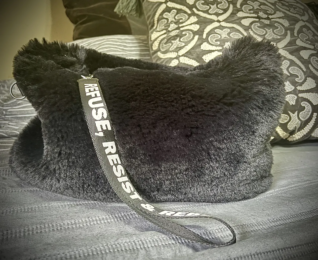 Sobre impecable! 💣 Negro, de pelo sintético con correa para mano estampada. Cierre principal plateado. 