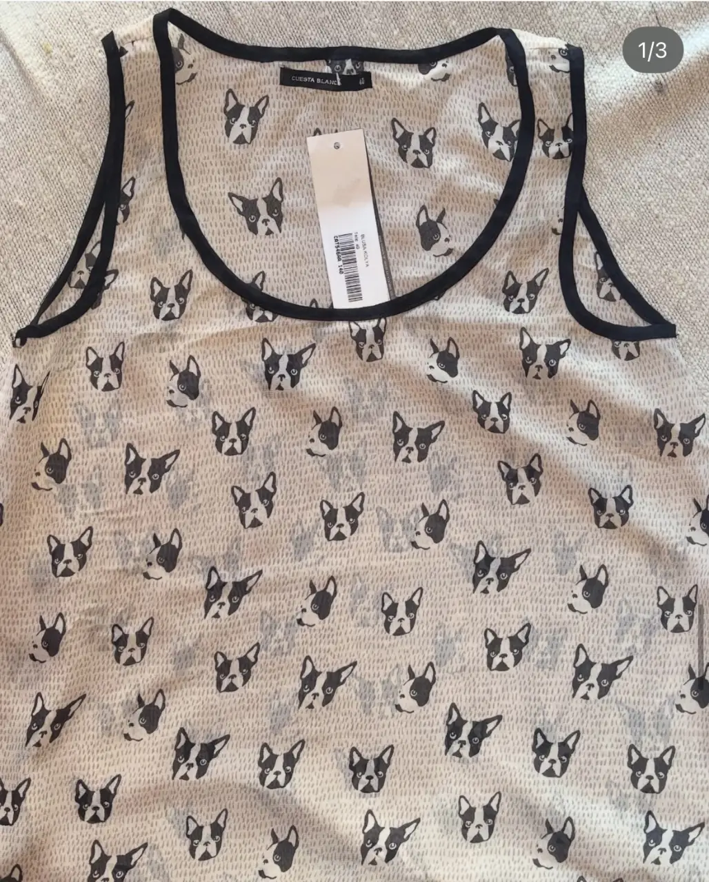 Musculosa de mujer con estampado de caras de bulldog francés. Tiene detalles en negro en el cuello y las sisas. La tela es liviana y fresca, ideal para el verano.