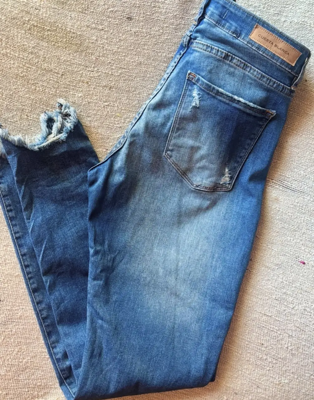Jeans de mujer Cuesta Blanca, tiro medio, con roturas y detalles desflecados. Talle 42.