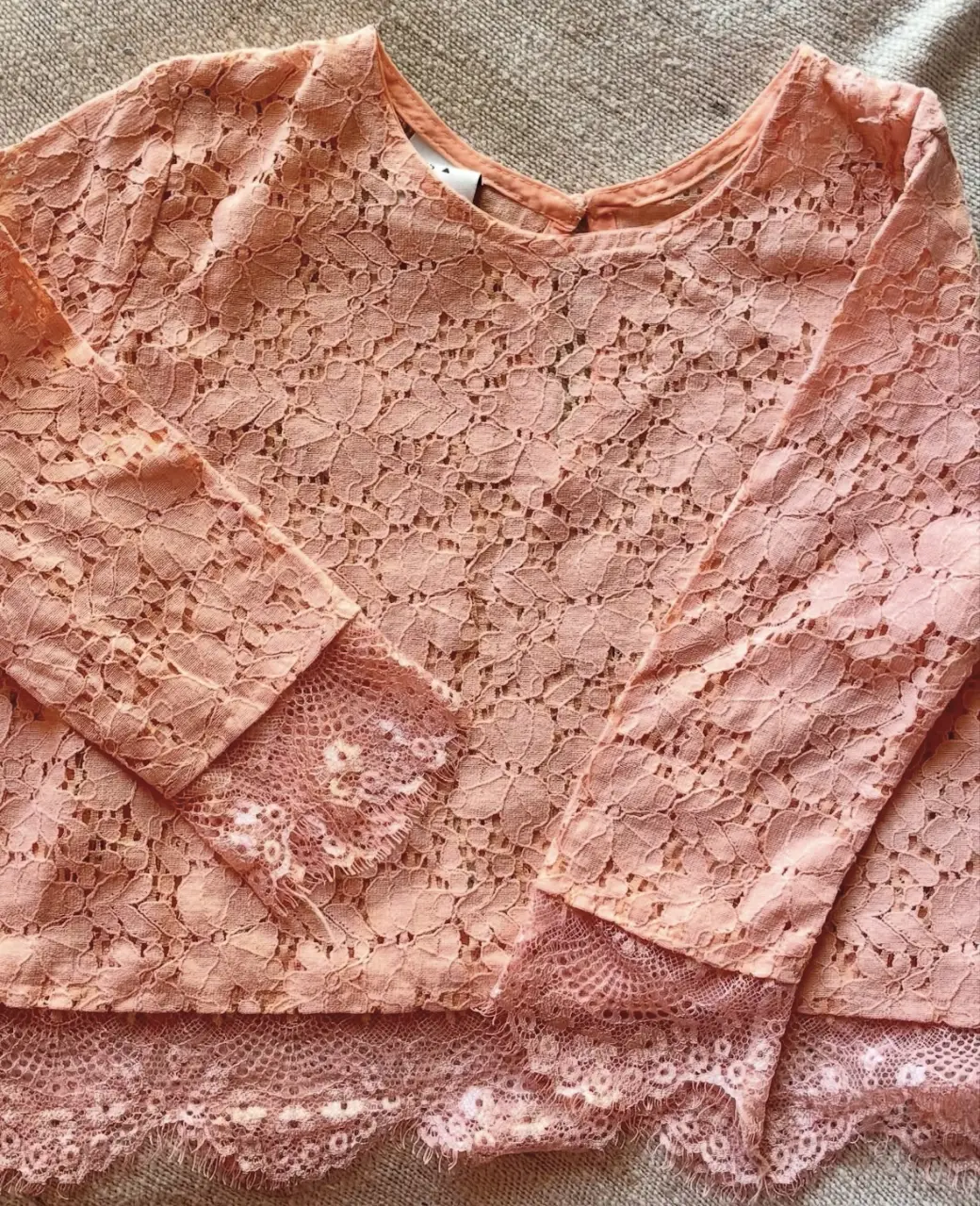 Blusa de encaje rosa, manga larga con detalle de encaje en los puños y en el borde inferior. Ideal para un look romántico y delicado.