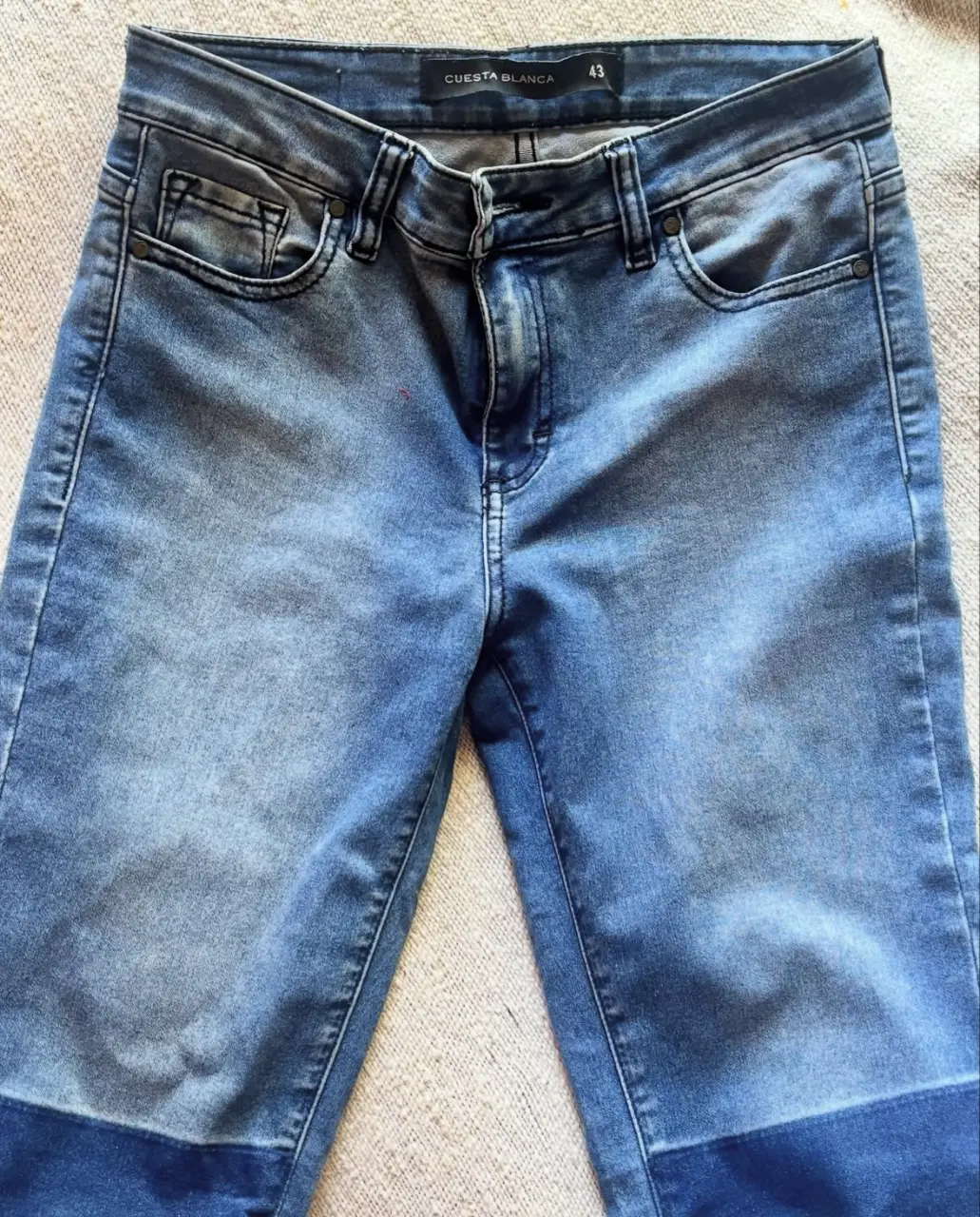 Jeans de mujer Cuesta Blanca, tiro medio, corte recto, con detalle de color en la parte inferior de la pierna. Talle 43.