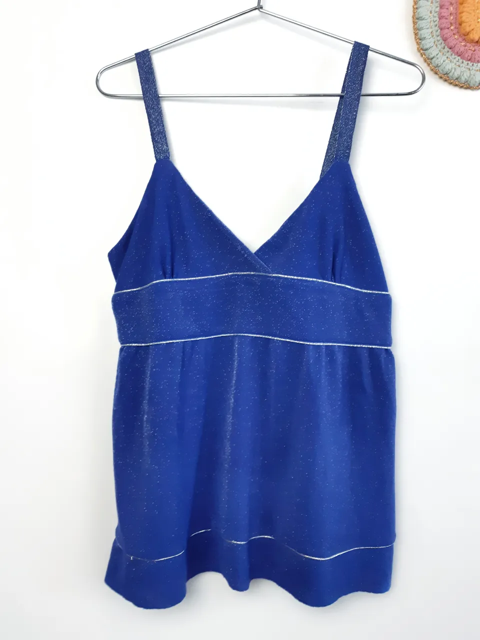 Top azul con brillos plateados y tiras finas. Posee detalles de finas líneas plateadas en el escote, bajo busto y ruedo.