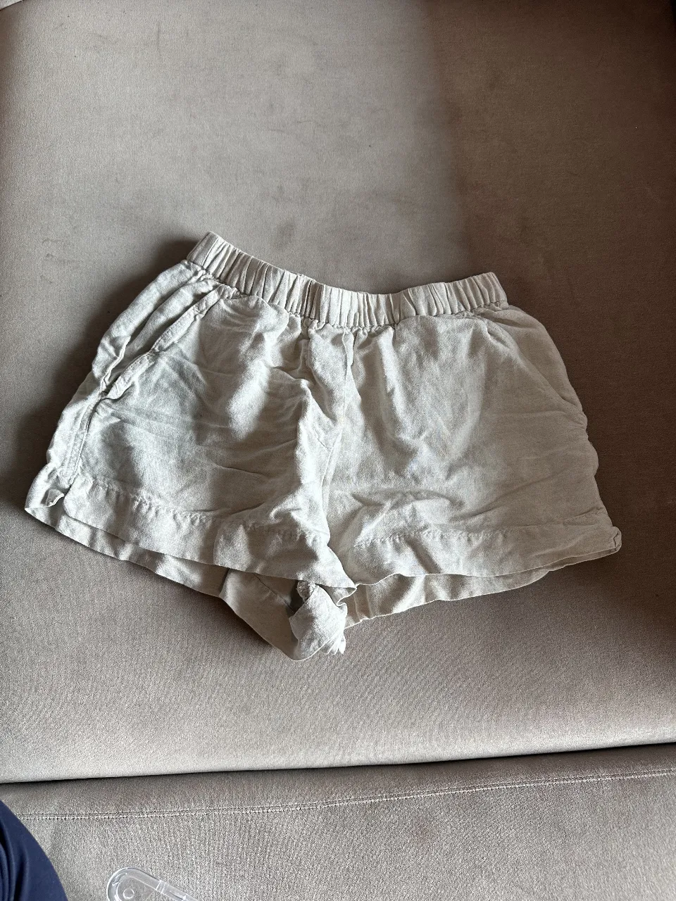 Short de 100% lino color crudo, tiro alto, con cintura elastizada y bolsillos laterales. 