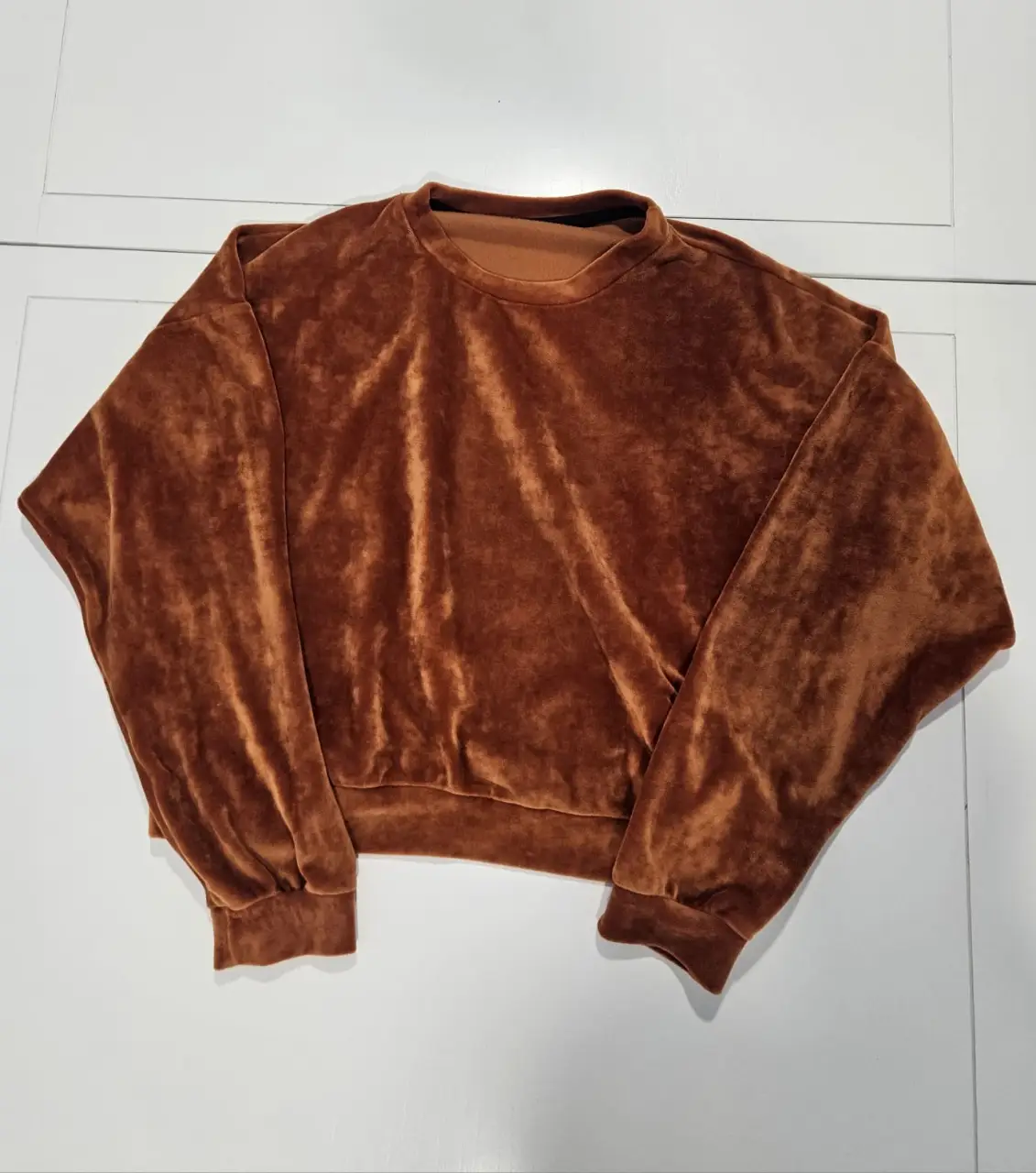 Buzo de terciopelo marrón, cuello redondo y mangas largas. Ideal para un look elegante y abrigado.
