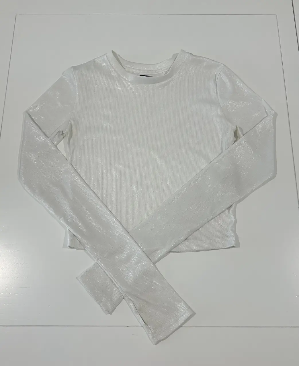 Remera manga larga blanca con detalle de abertura en la manga. Ideal para un look moderno y elegante.