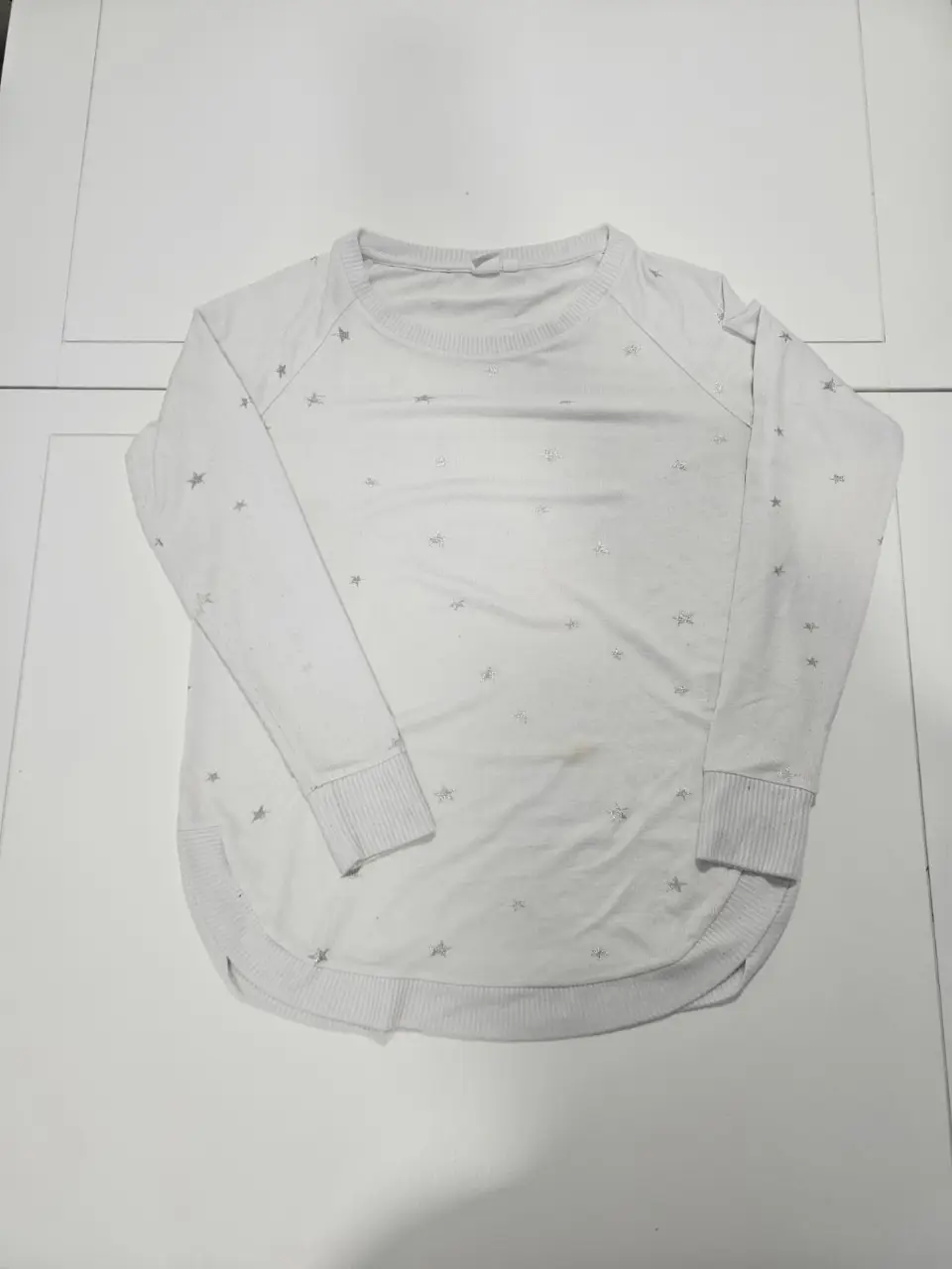 Sweater blanco de cuello redondo con detalles de estrellas plateadas. Talle XS, ideal para un look casual y cómodo.