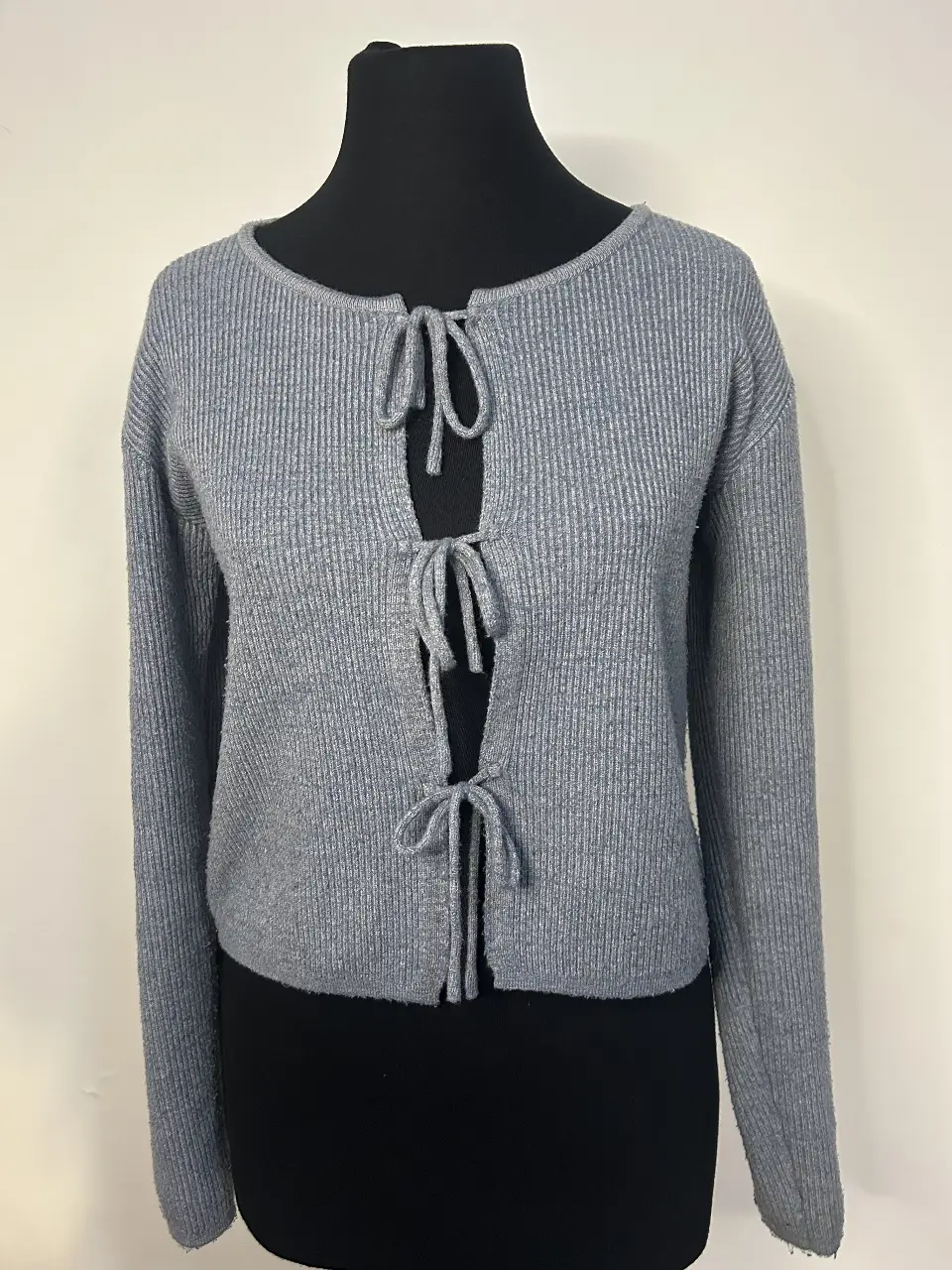 Cardigan gris con lazos frontales. Ideal para un look casual y moderno.