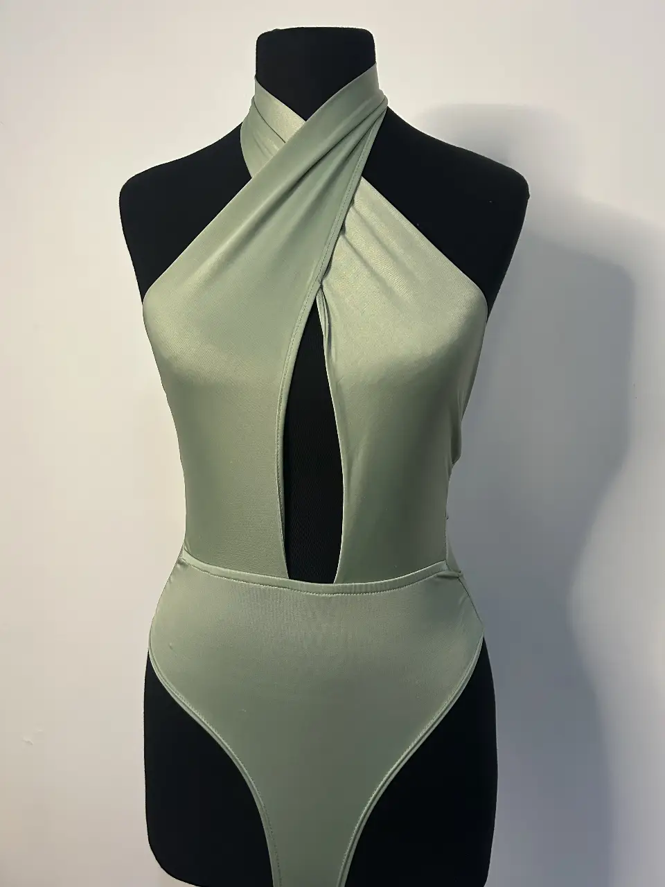 Body enterizo de color verde con diseño halter y abertura frontal. ideal para usar de día  con un estilo moderno y elegante.