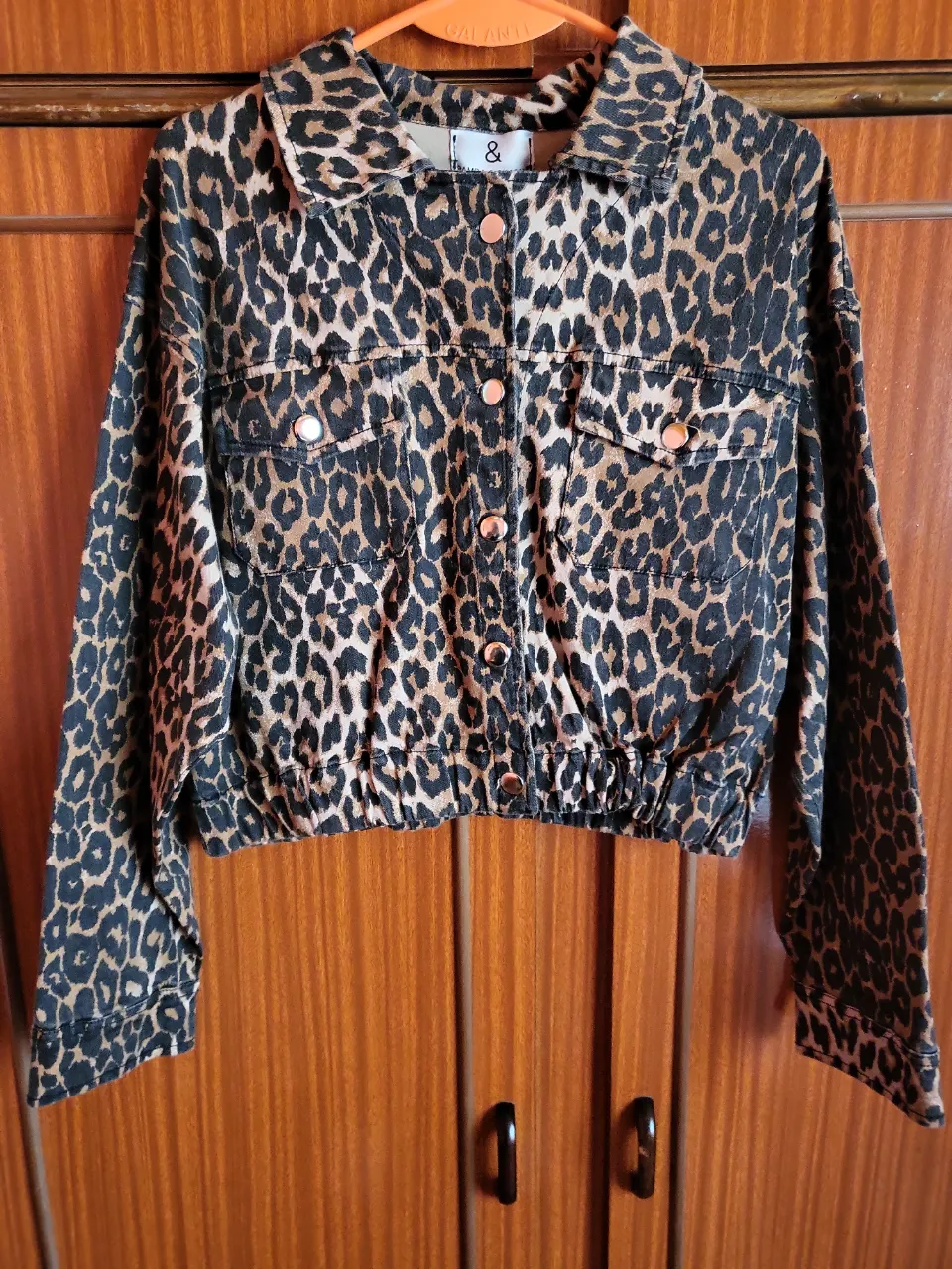 Campera de jean con estampa de leopardo. Tiene botones metálicos y bolsillos en el frente. Elástico en la cintura.