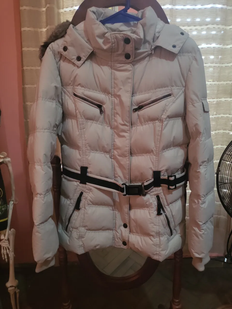 Campera acolchada de invierno con cinto y detalles de eco cuero. Posee capucha con piel sintética desmontable. Ideal para días fríos y salidas casuales.