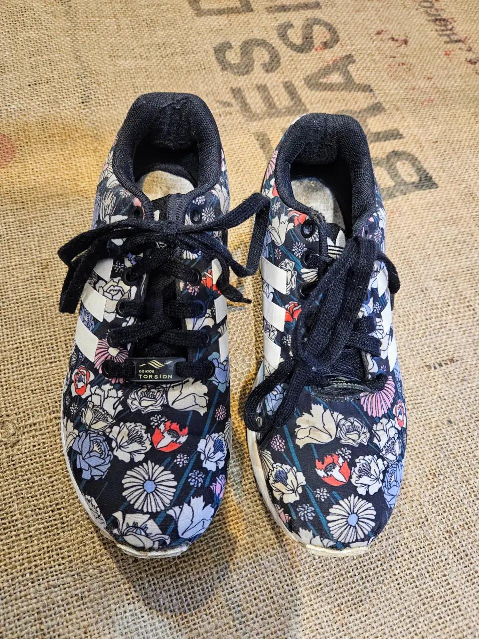 Zapatillas Adidas ZX Flux con estampado floral. Talle 6 US. Diseño con las tres tiras blancas características de la marca. Ideales para un look casual y moderno.