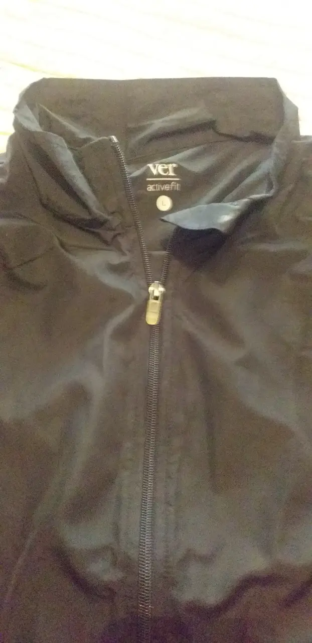 Campera rompevientos negra, ideal para actividades deportivas o uso casual. Con cierre frontal y cuello alto.