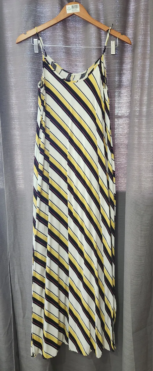 Vestido largo a rayas verticales blancas, amarillas, negras y finas líneas rosas. Breteles finos.