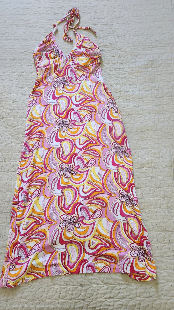 Vestido largo estampado con cuello halter y tiras anudadas en la nuca. Posee un estampado abstracto en tonos rosas, naranjas, amarillos y blancos.
