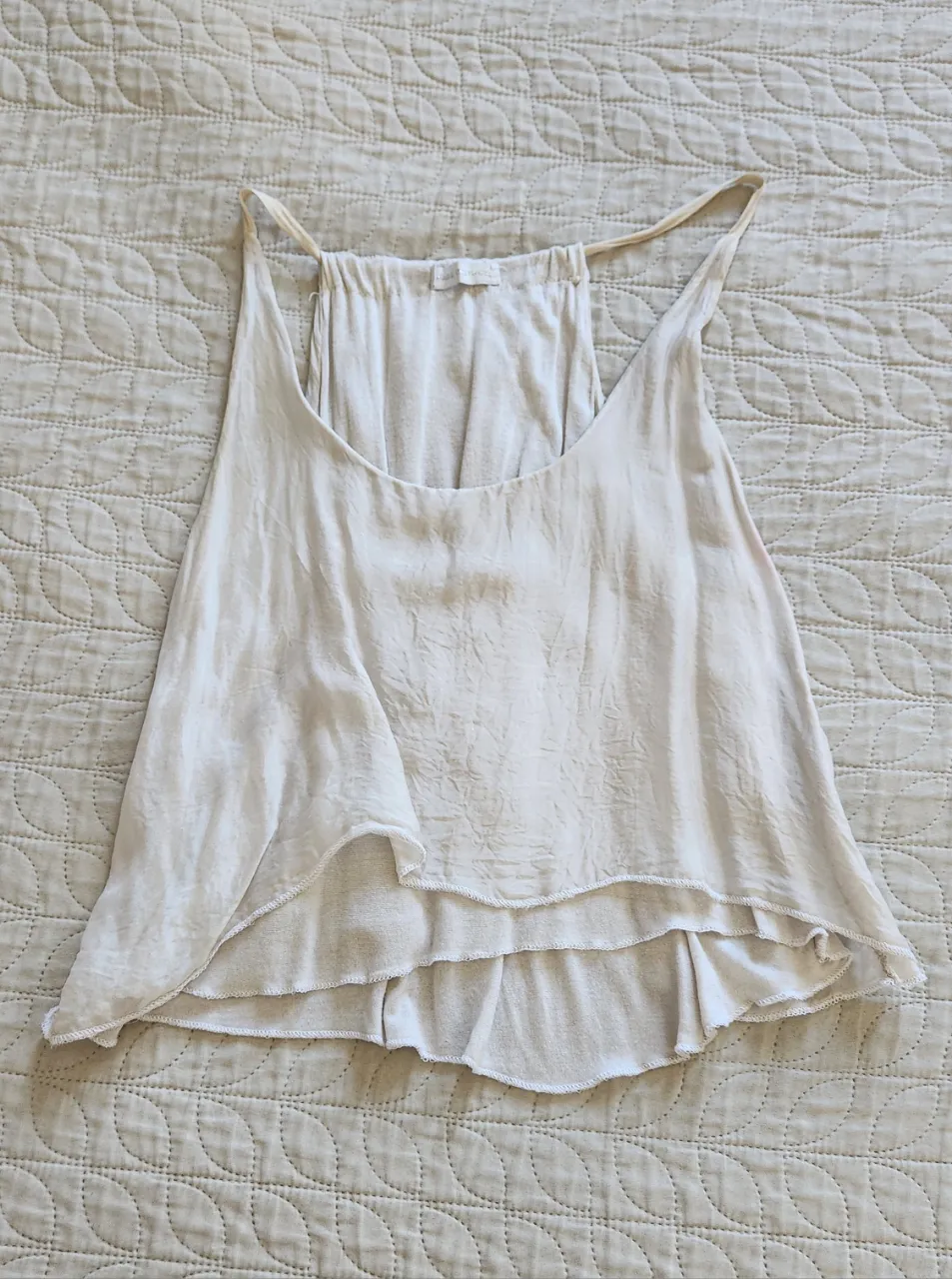 Musculosa blanca con volados en la parte inferior. Breteles finos.
