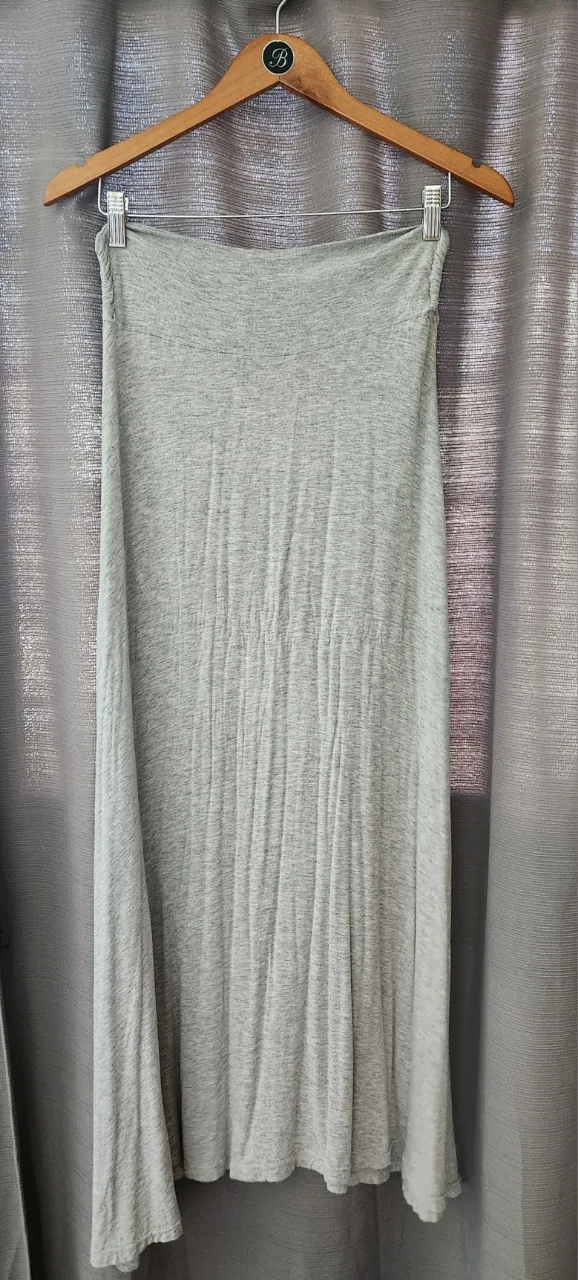 Pollera larga gris de tela. Posee un elástico en la cintura.