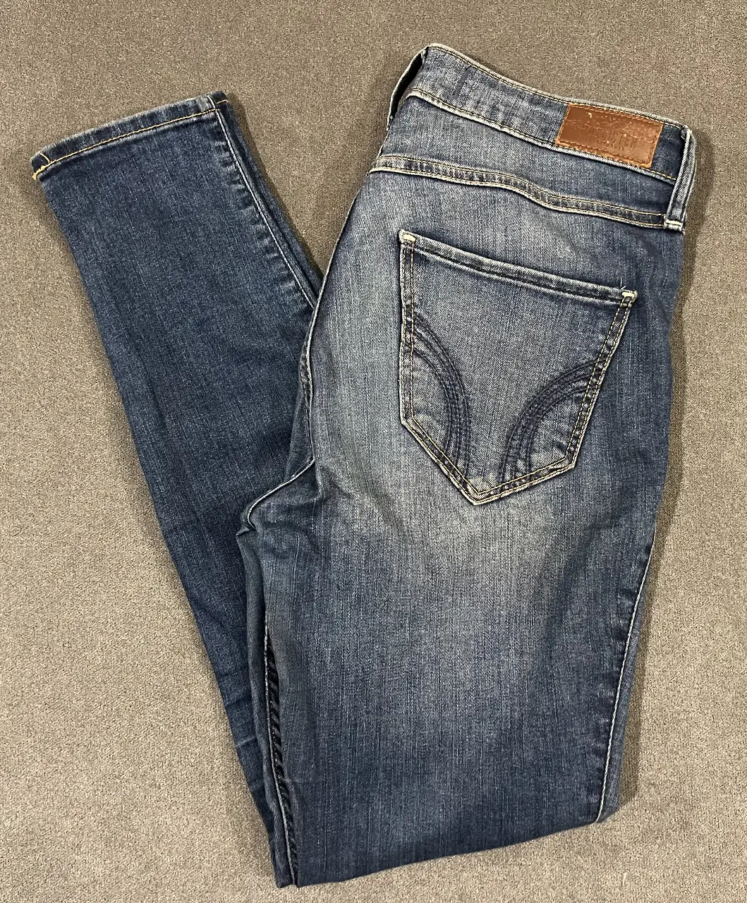 Jeans Hollister de tiro alto, color azul, con bolsillos traseros y delanteros. Chupin / Skinny. Talle US 26.