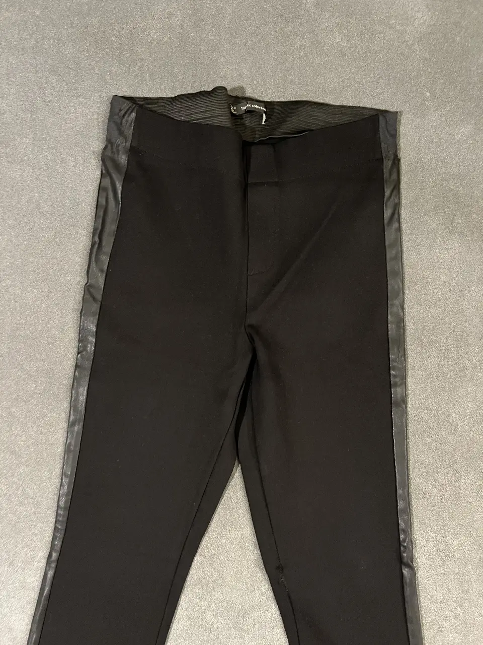 Calza negra con detalle de cuero sintético en los laterales. Talle M. Ideal para un look elegante y moderno. El cuero de los laterales está medio gastado