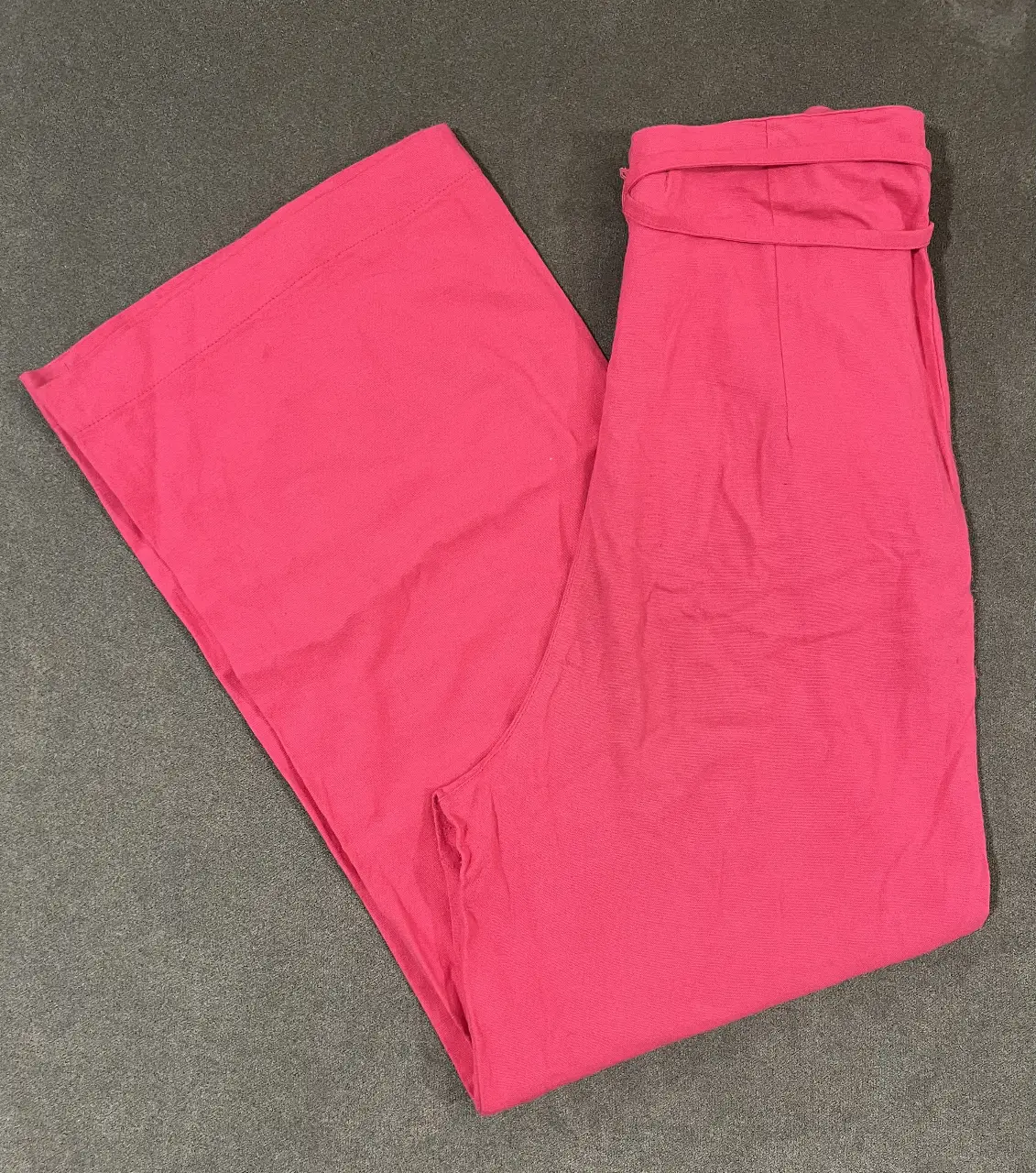 Pantalón suelto de mujer, color fucsia, con cintura alta y lazo para ajustar. Ideal para un look casual y cómodo. tiene un poco de pelotitas atrás en la cola