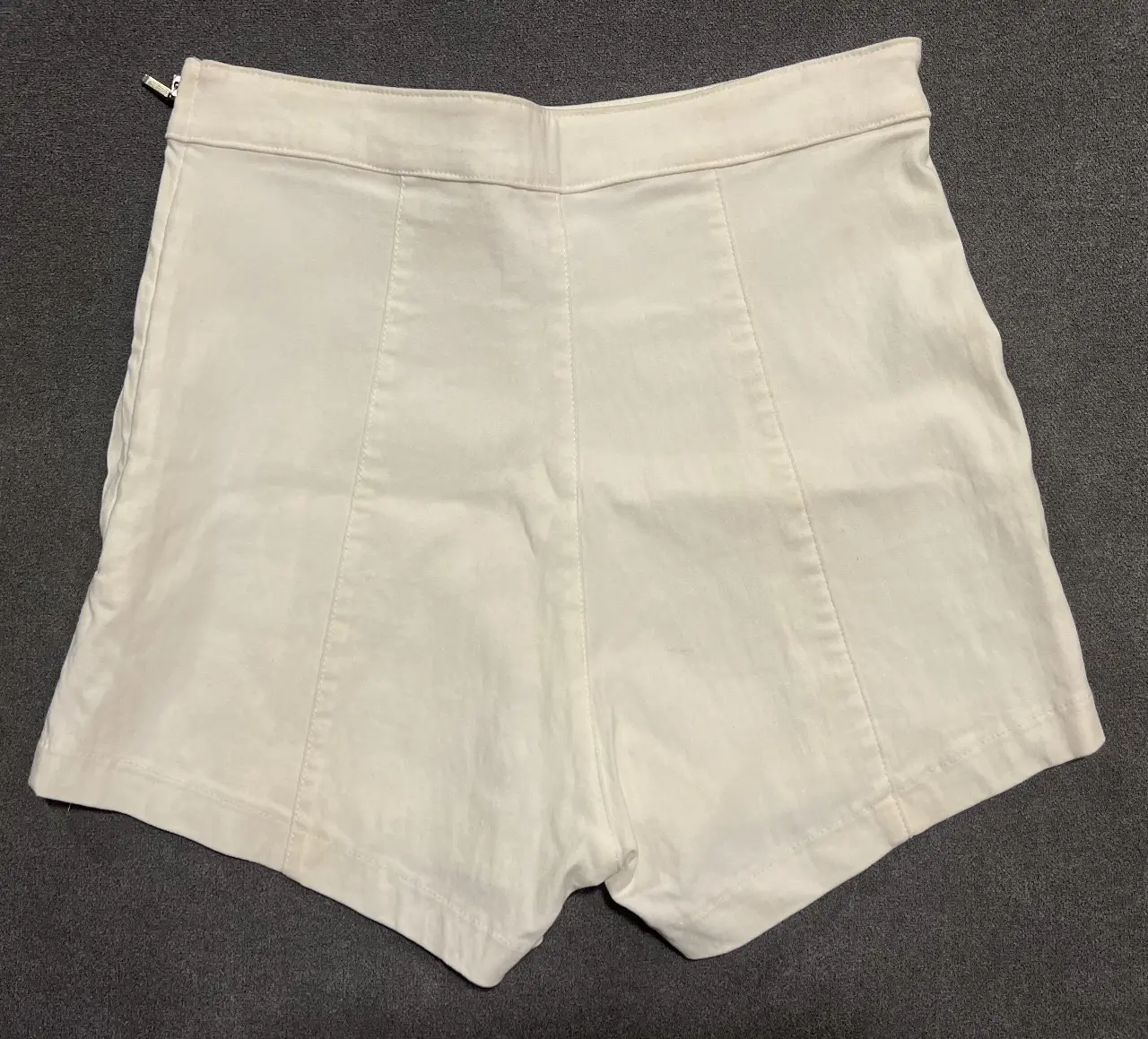 Short de mujer tiro alto, color blanco, con detalles de costura y cierre en la parte trasera. Ideal para un look casual y moderno.