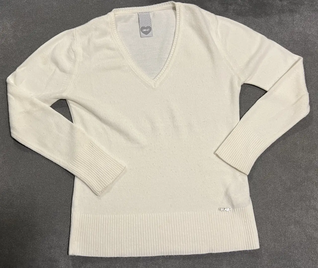 Sweater blanco con cuello en V, ideal para un look casual y cómodo. Perfecto para combinar con jeans o pantalones de vestir. 