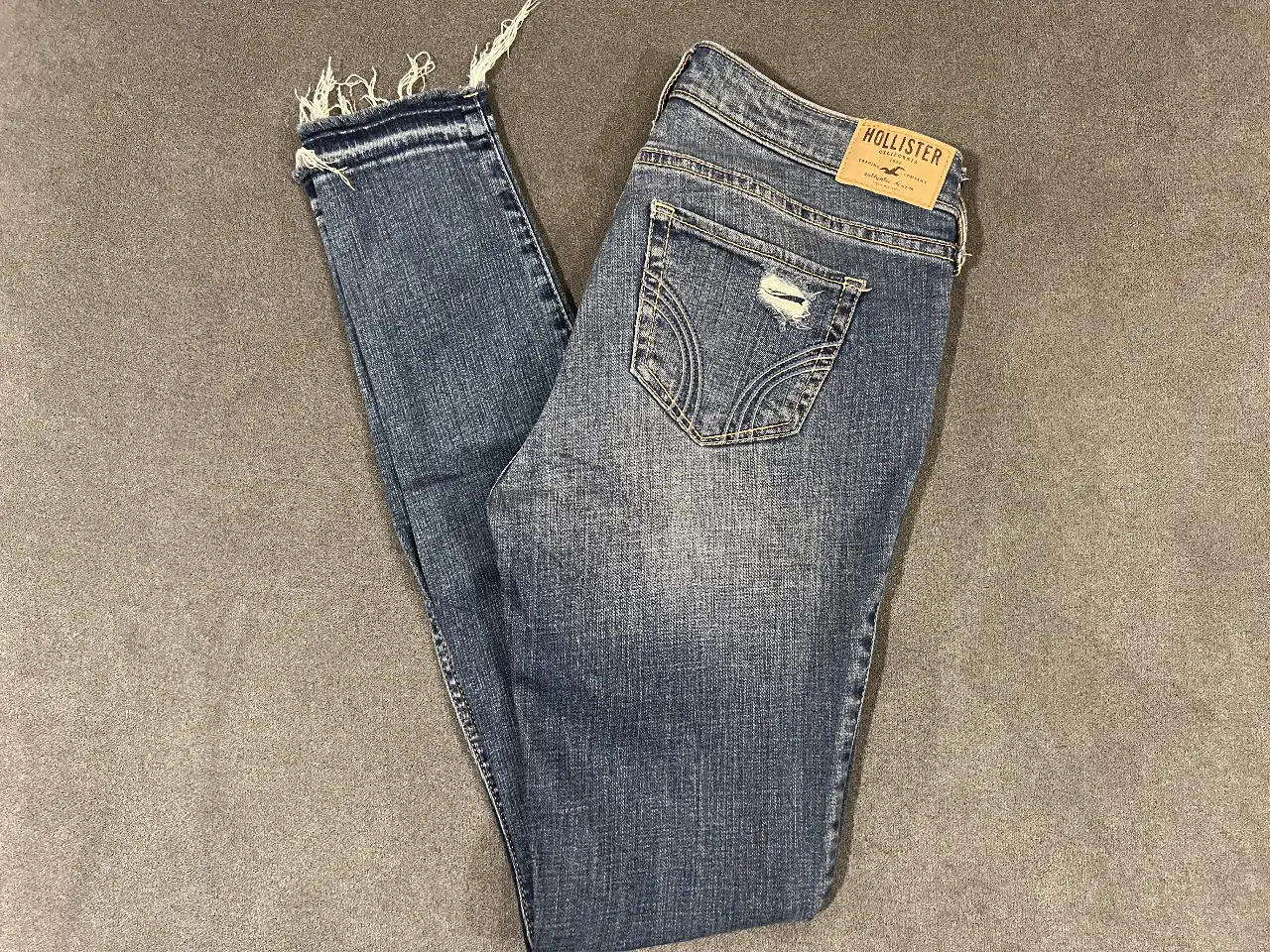 Jeans Hollister de mujer, tiro medio, con roturas y detalles desflecados. Chupin / Skinny. Talle US 27.
