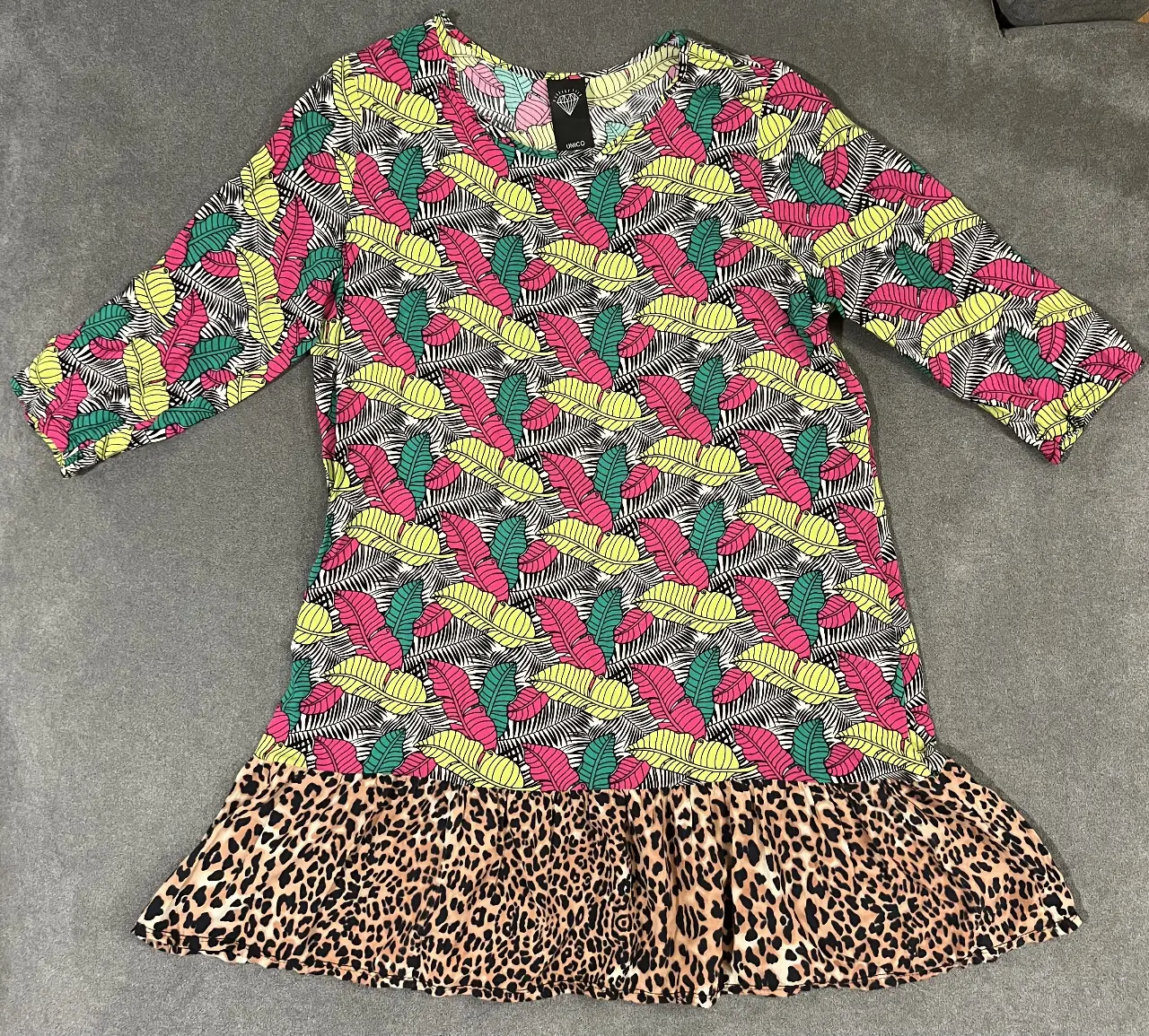 Vestido mini con estampado de hojas en tonos vibrantes y detalle de animal print en la falda. Ideal para un look moderno y llamativo.