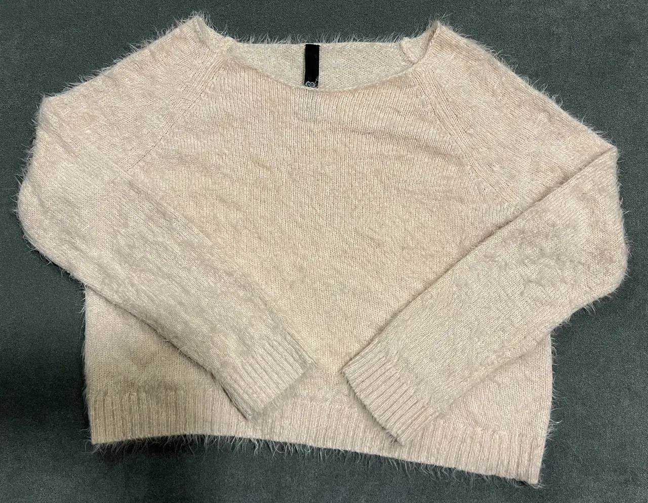 Sweater de mujer, color rosa claro, tejido suave y peludo, ideal para un look casual y abrigado. Cuello redondo y mangas largas.
