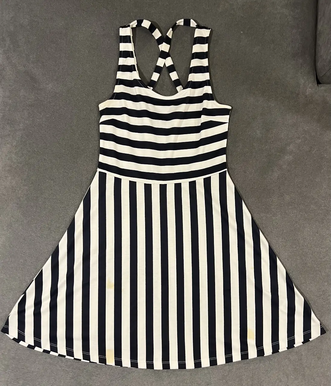 Vestido mini de mujer, a rayas verticales en blanco y negro. Con espalda cruzada y escote redondo. Ideal para un look casual y fresco. Tiene unas manchitas amarillas adelante (ver 1er foto)