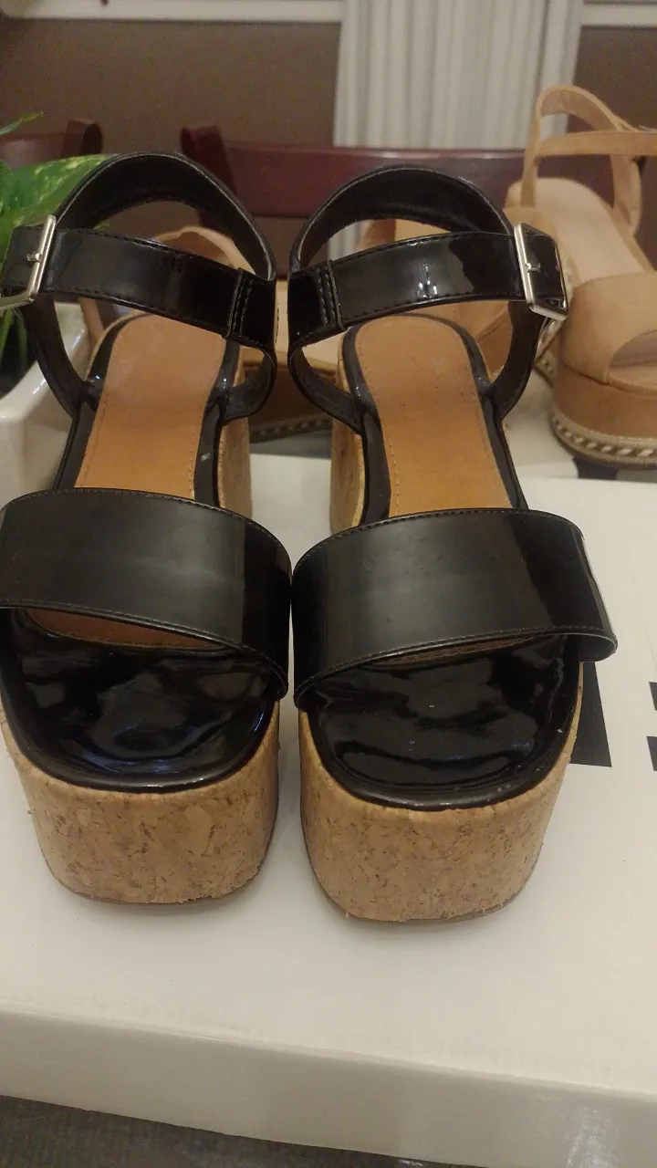 Sandalias negras con plataforma de corcho y tiras al frente. Sandalias color suela con plataforma y tiras al frente. Zapatos chatos color suela con tira trasera.