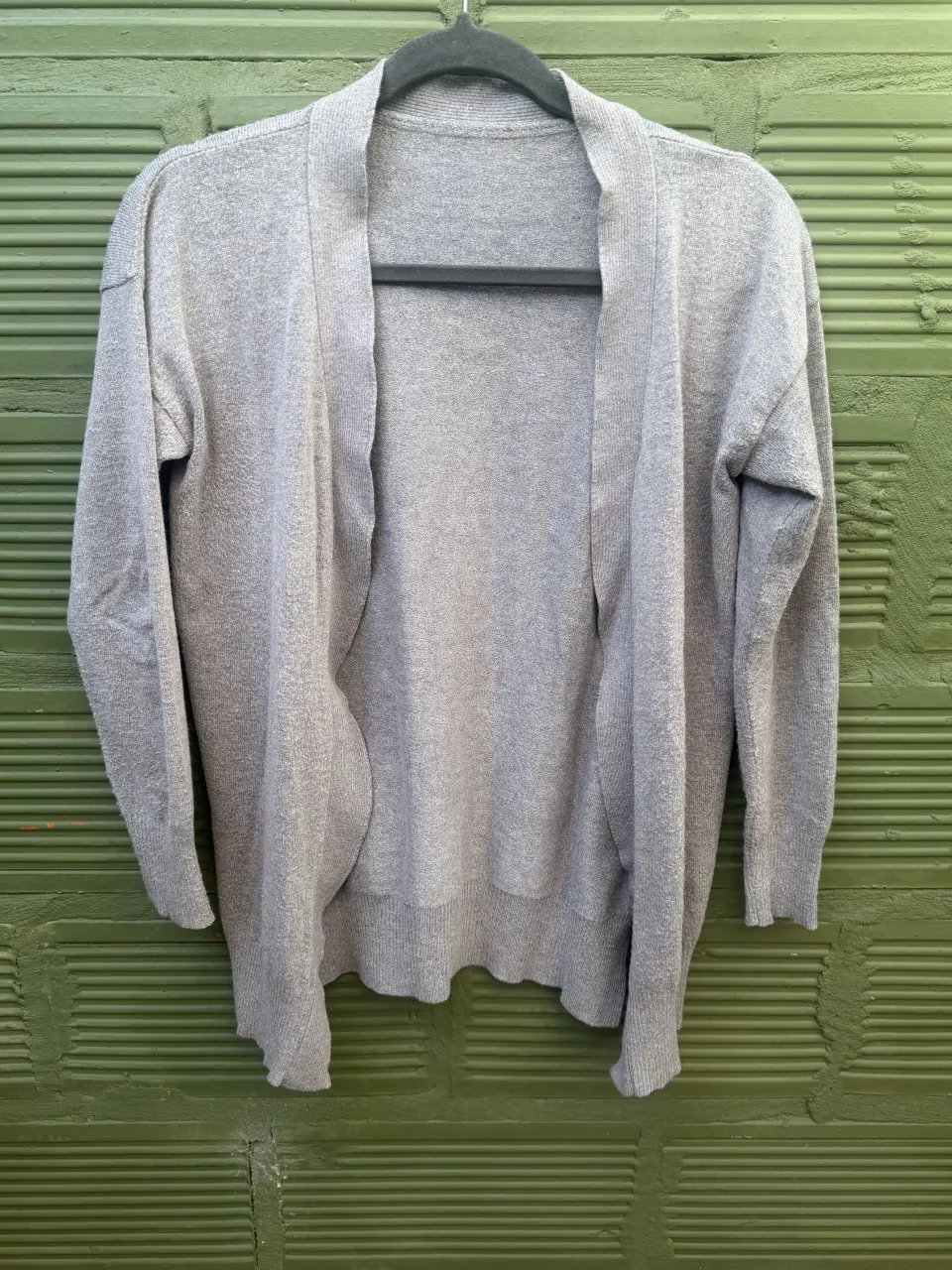 Cardigan gris de tejido de punto. Manga larga y escote abierto. Súper suave