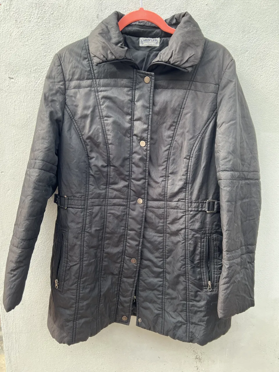 Campera negra acolchada con cuello alto y cierre.