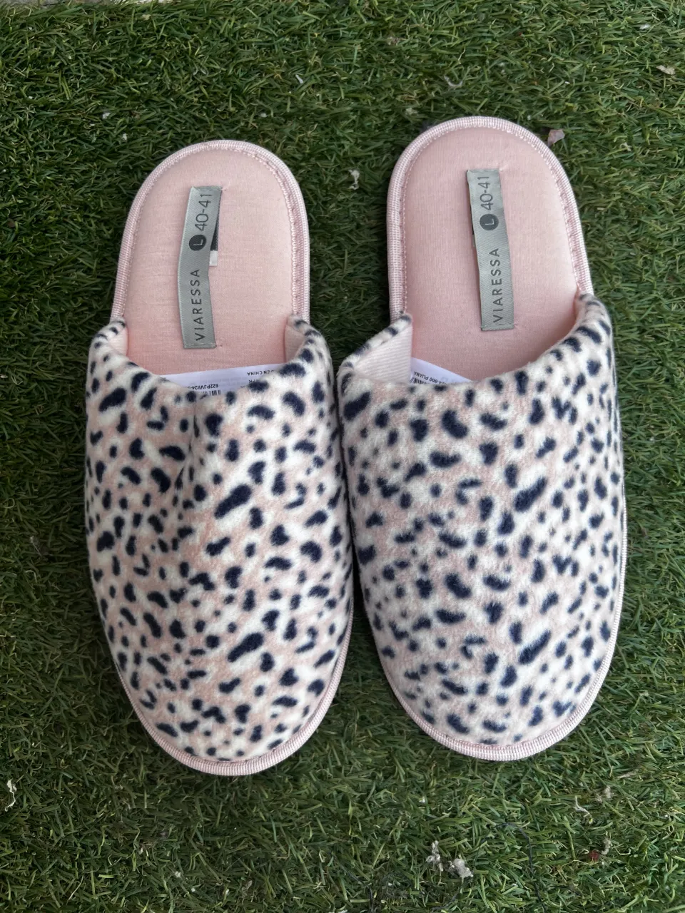 Pantuflas con estampa de leopardo en tonos rosa pálido y negro. Detalle en el borde y forro interior en rosa.